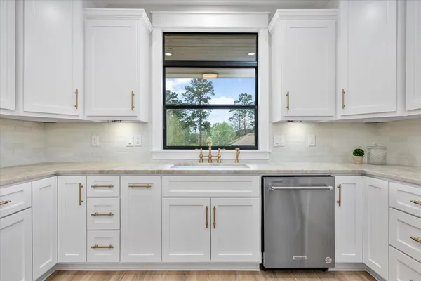 a kitchen with white cabinets and sink