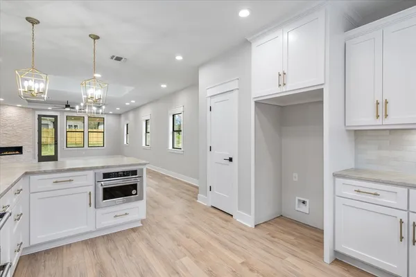 a kitchen with kitchen island white cabinets and stainless steel appliances