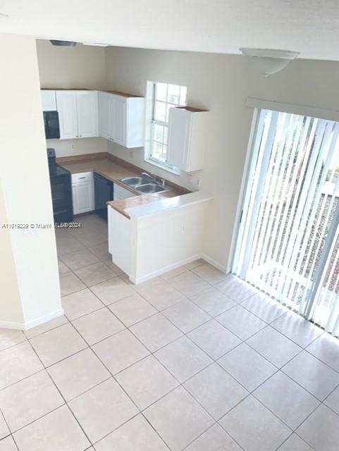 2133 Northeast 7th Street, Unit 2133 Homestead, FL 33033 - Photo 22 of 28 a kitchen with a sink a stove and cabinets