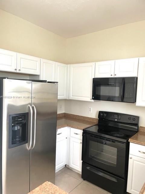 2133 Northeast 7th Street, Unit 2133 Homestead, FL 33033 - Photo 9 of 28 a kitchen with stainless steel appliances a stove a microwave and a refrigerator