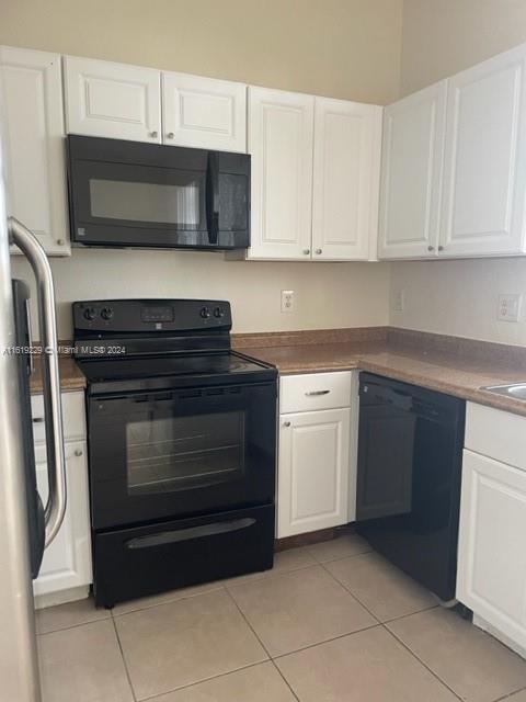 2133 Northeast 7th Street, Unit 2133 Homestead, FL 33033 - Photo 10 of 28 a kitchen with granite countertop white cabinets and stainless steel appliances