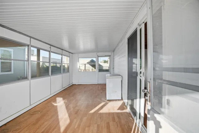 a view of empty room with wooden floor