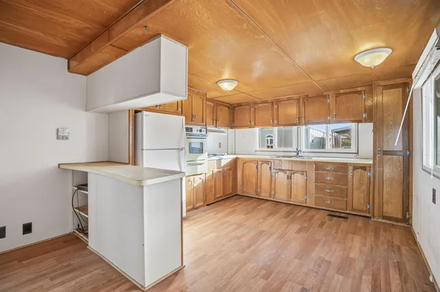 a kitchen with cabinets and wooden floor