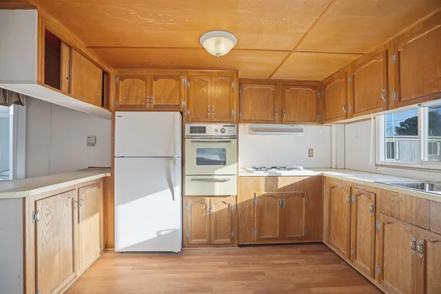 a kitchen with stainless steel appliances granite countertop a refrigerator and a sink