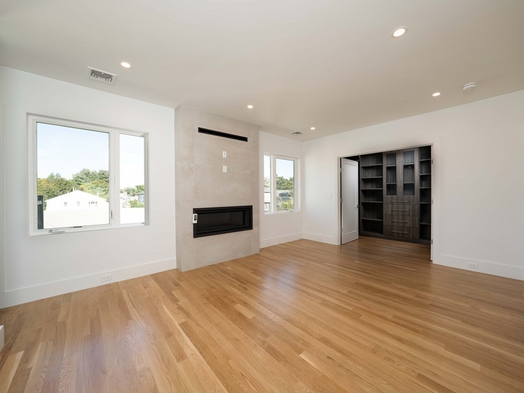 21 Cavanaugh Path Newton, MA 02459 - Photo 11 of 30 an empty room with wooden floor and windows