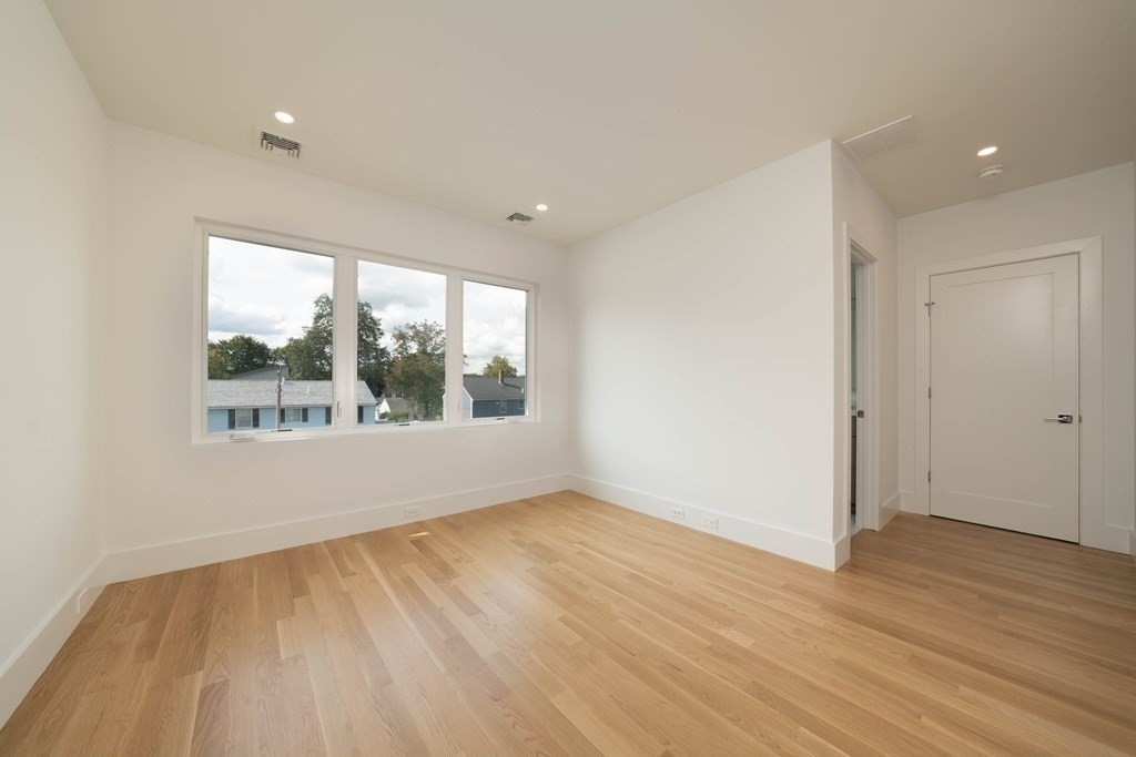 21 Cavanaugh Path Newton, MA 02459 - Photo 15 of 30 a view of an empty room with wooden floor and a window