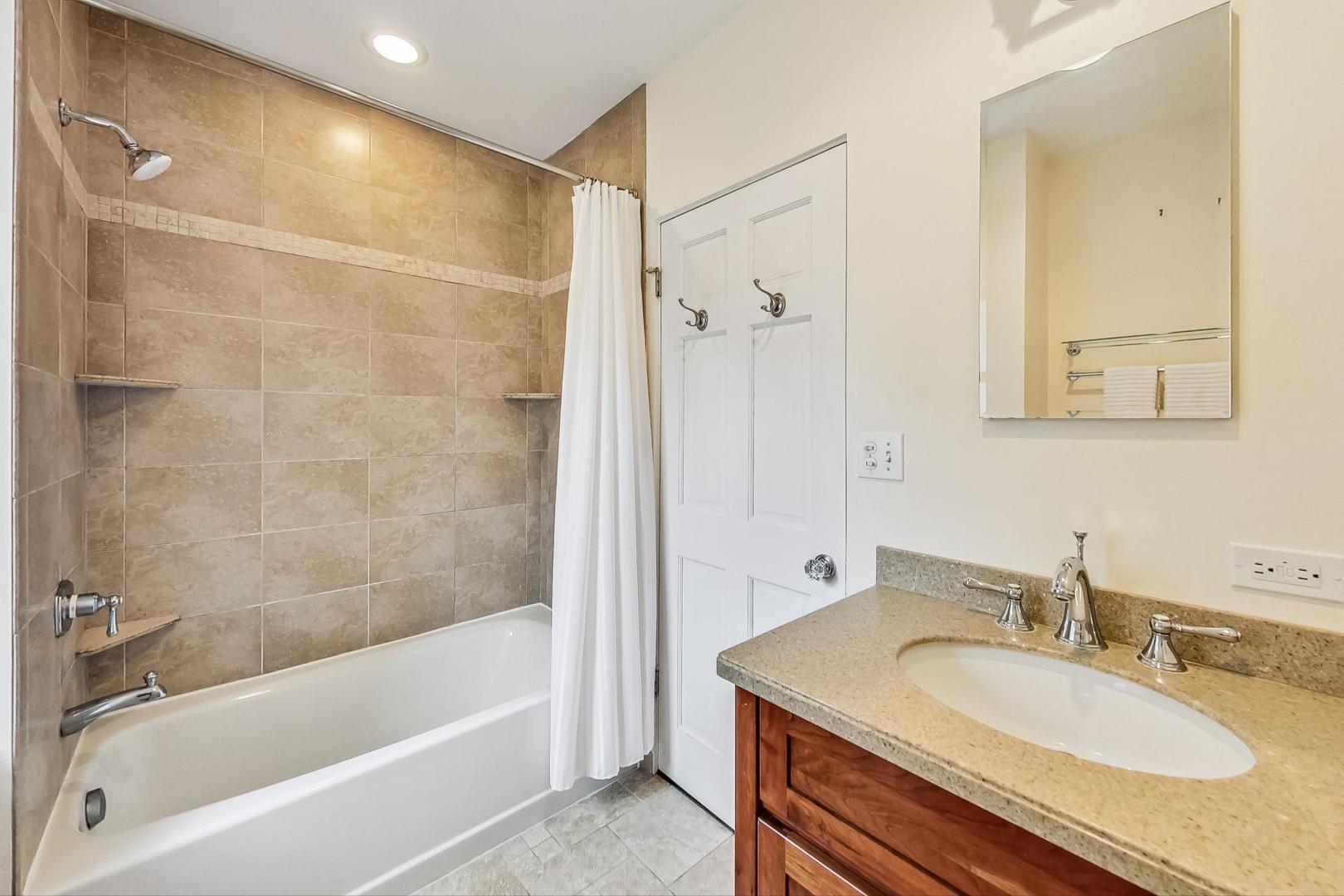 1701 Walnut Avenue Wilmette, IL 60091 - Photo 21 of 30 a bathroom with a granite countertop sink a mirror a bathtub and shower