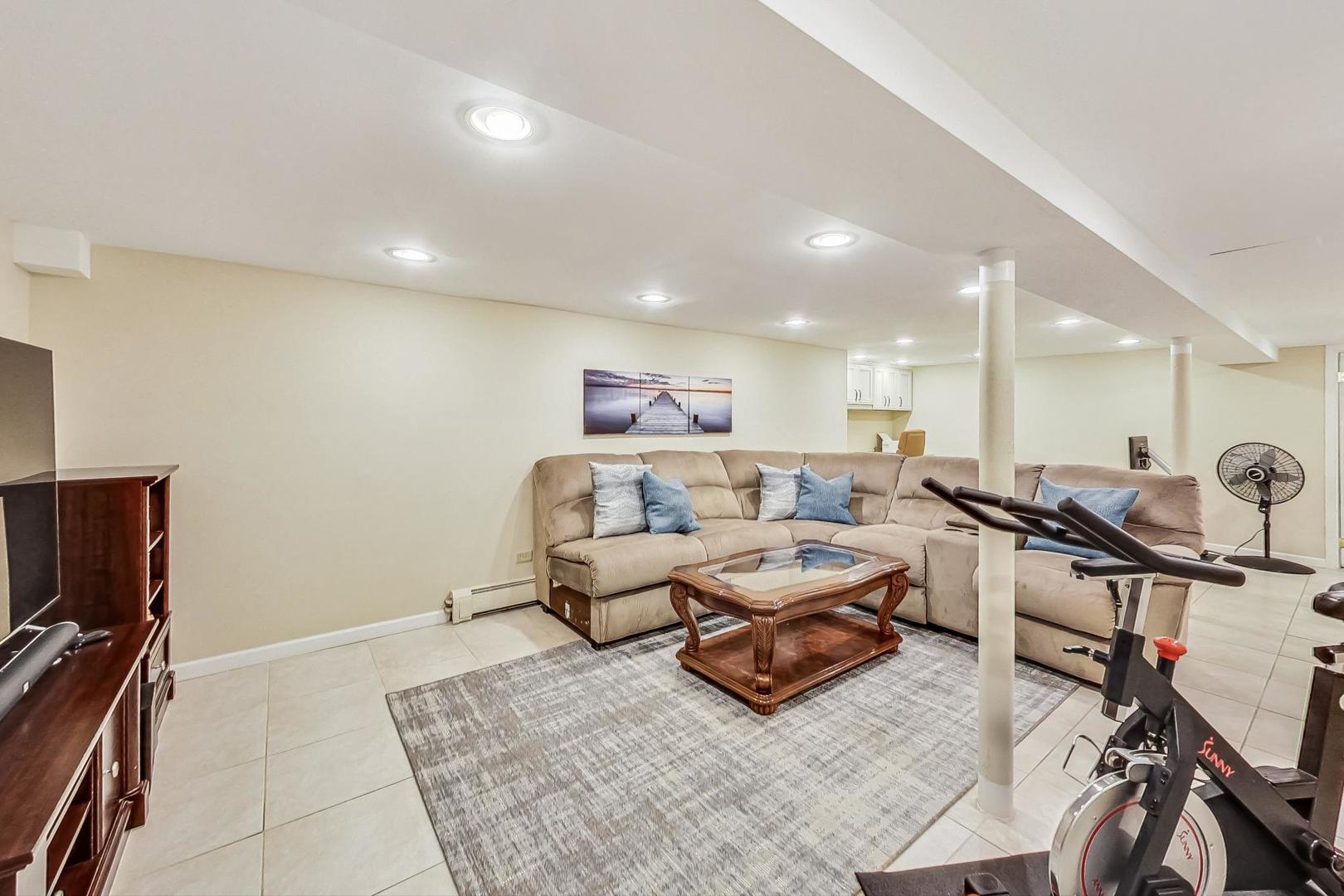 1701 Walnut Avenue Wilmette, IL 60091 - Photo 22 of 30 a living room with furniture a flat screen tv and a table