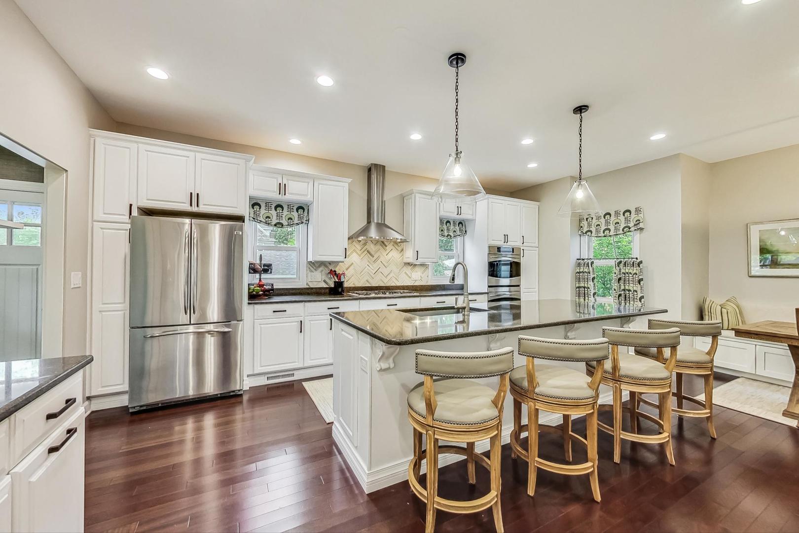 1701 Walnut Avenue Wilmette, IL 60091 - Photo 8 of 30 a kitchen with stainless steel appliances granite countertop a table chairs stove and refrigerator