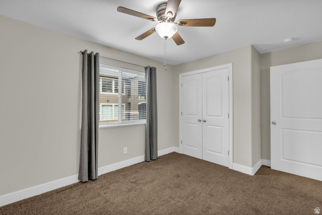 905 South Main Street, Unit G Layton, UT 84041 - Photo 13 of 36 Unfurnished bedroom featuring dark colored carpet, a closet, and a ceiling fan