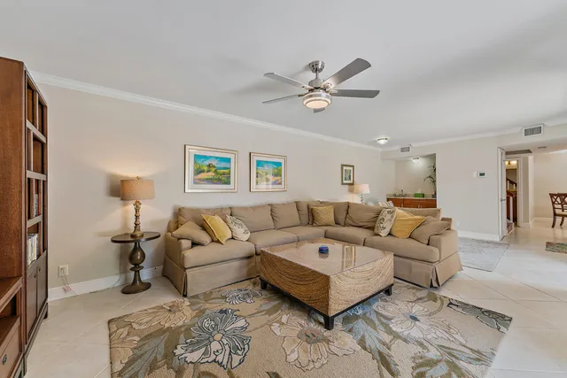 a living room with furniture and a ceiling fan