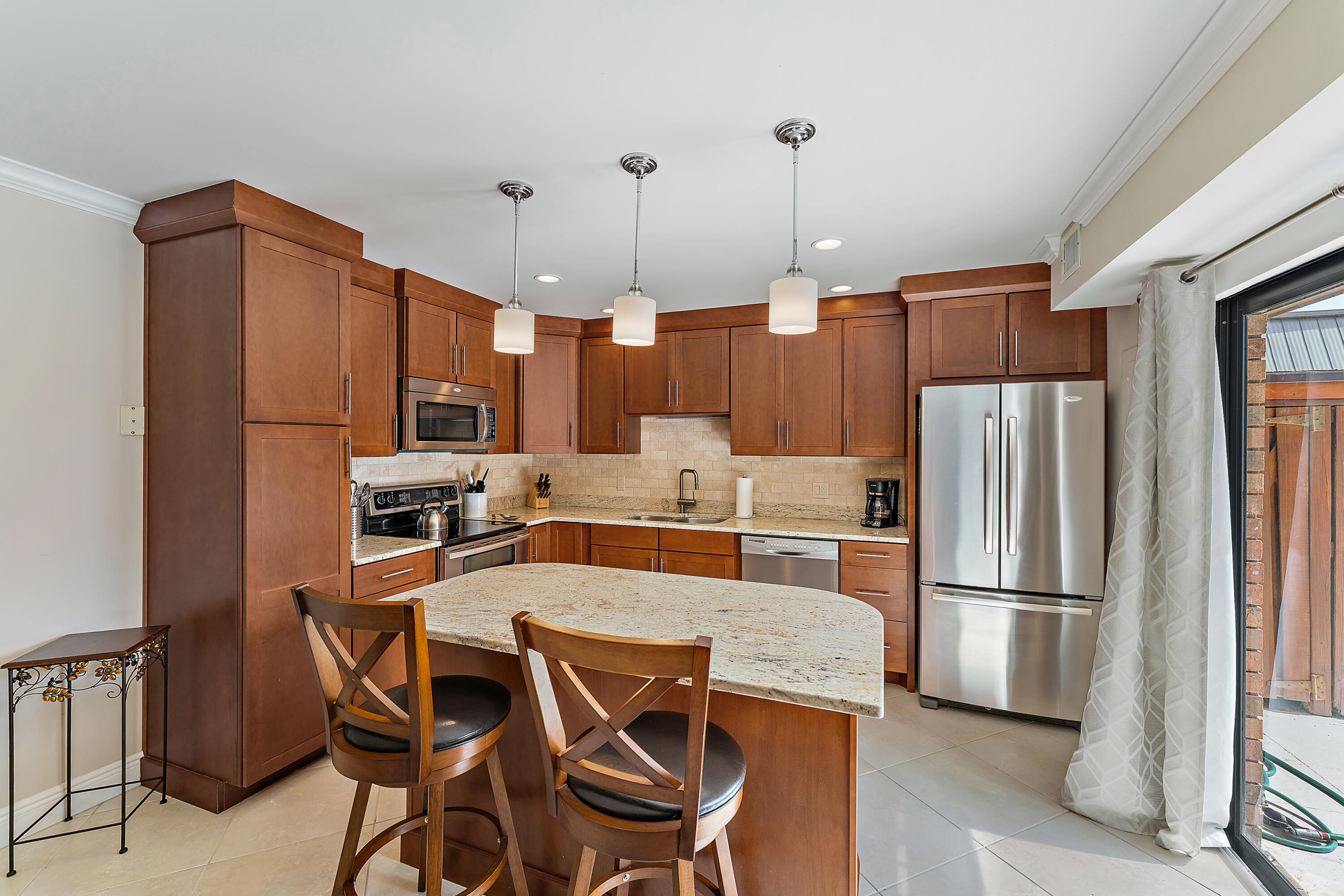 1420 Ocean Way, Unit 14C Jupiter, FL 33477 - Photo 20 of 41 a kitchen with stainless steel appliances granite countertop a refrigerator a microwave and wooden floor