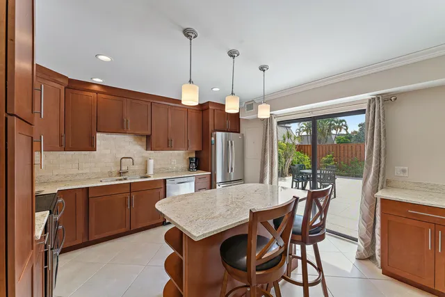 a kitchen with granite countertop a dining table chairs and white cabinets