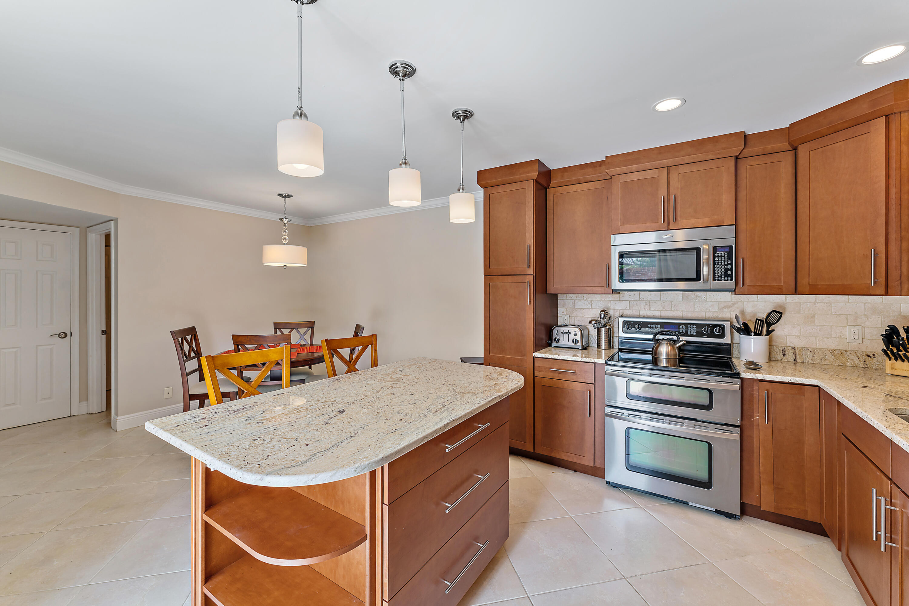 1420 Ocean Way, Unit 14C Jupiter, FL 33477 - Photo 23 of 41 a kitchen with stainless steel appliances granite countertop a stove a sink dishwasher and a refrigerator