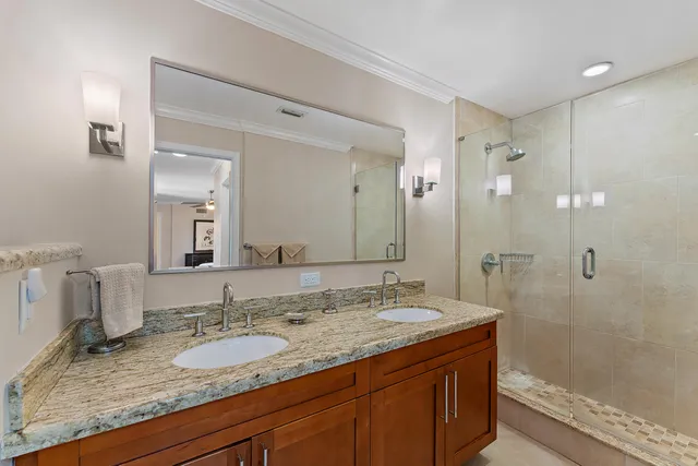 a bathroom with a granite countertop sink mirror and shower