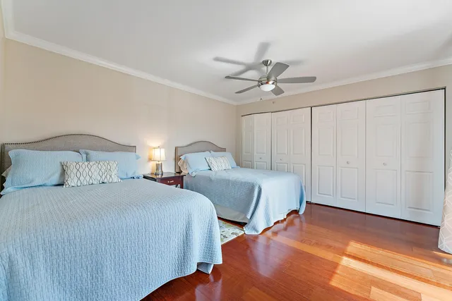 a bedroom with two beds and a ceiling fan