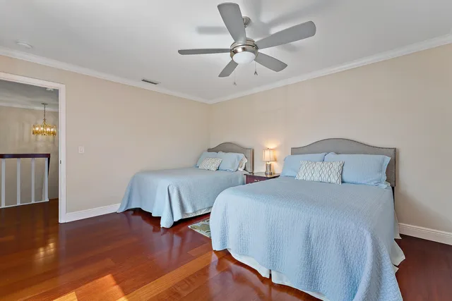 a bedroom with two beds and painting on the wall