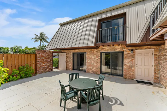 a view of a house with backyard and sitting area