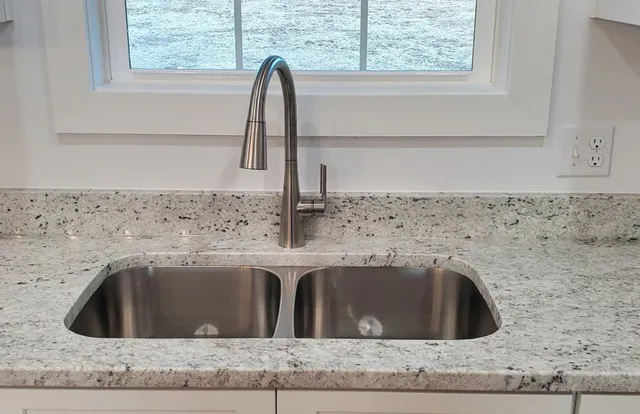 an empty room with wooden floor ceiling fan and windows