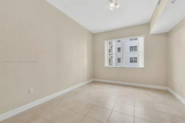 an empty room with windows and ceiling fan