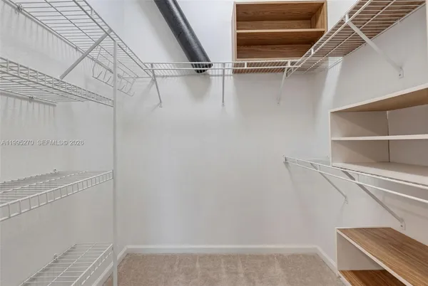 a view of walk in closet with empty racks