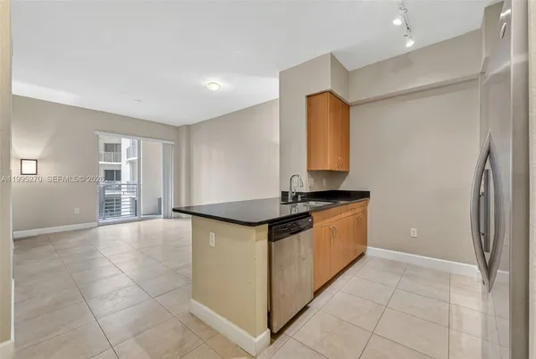 a large kitchen with granite countertop a sink and a stove top oven