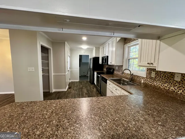 a kitchen with sink refrigerator and cabinets