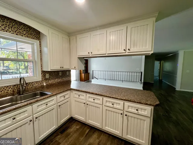 a kitchen with granite countertop white cabinets and white appliances