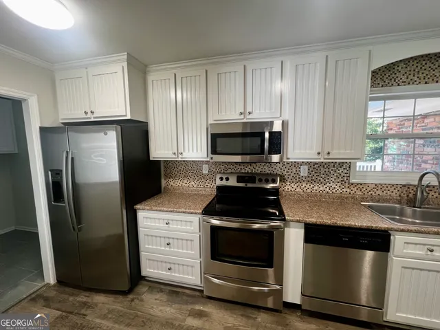 a kitchen with white cabinets and stainless steel appliances