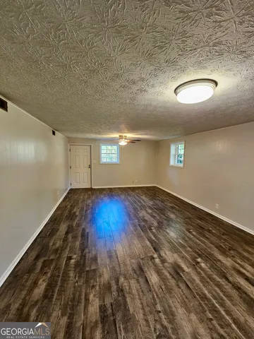 a view of a backyard with plants and wooden fence