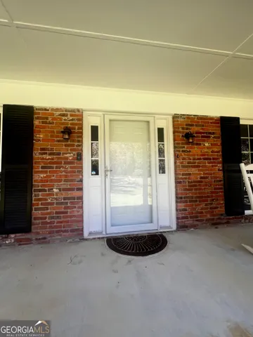 a view of an empty room with brick walls