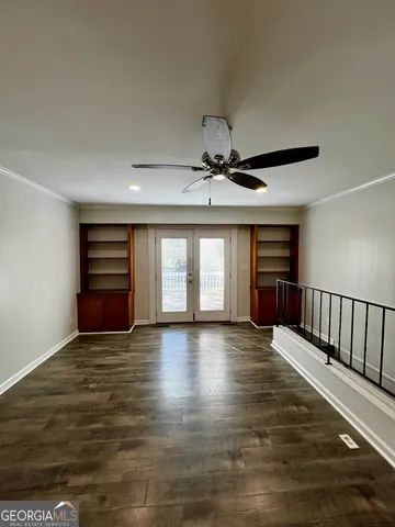 a view of an empty room with window and wooden floor