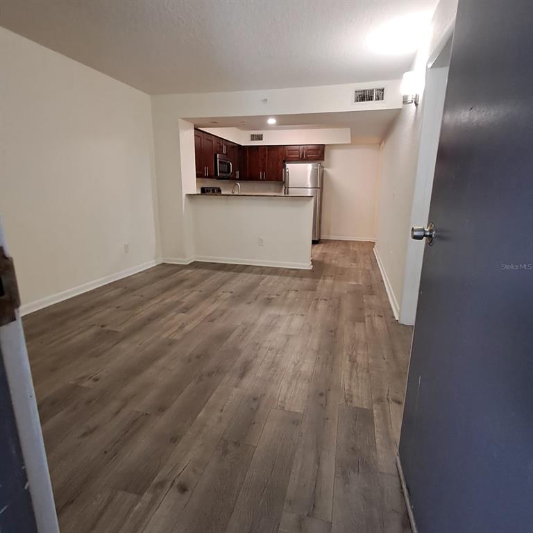 2323 McCoy Road, Unit 711 Orlando, FL 32809 - Photo 3 of 14 a view of empty room with wooden floor