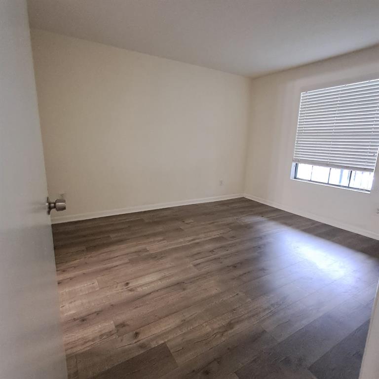 2323 McCoy Road, Unit 711 Orlando, FL 32809 - Photo 6 of 14 an empty room with wooden floor and windows