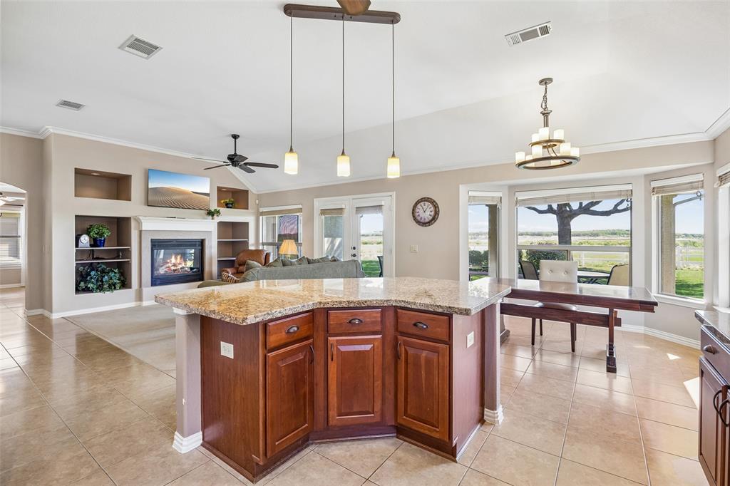 9221 Perimeter Street Denton, TX 76207 - Photo 12 of 36 a kitchen with stainless steel appliances granite countertop a stove top oven a sink dishwasher and a fireplace with wooden floor