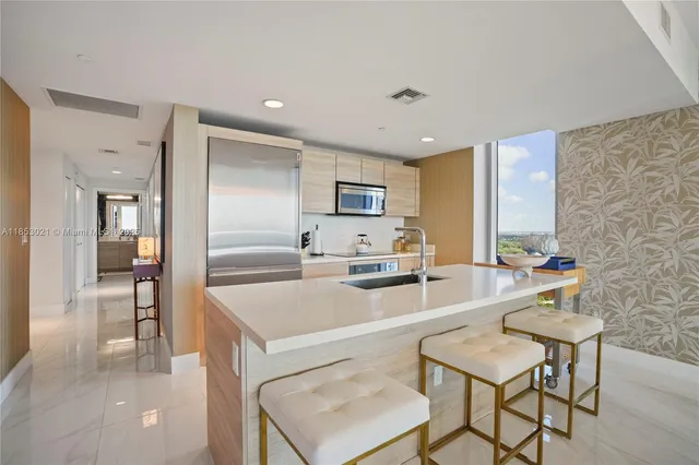a large white kitchen with a large window a stove and a refrigerator