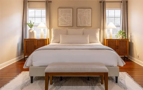 a bed sitting in a bedroom next to a window