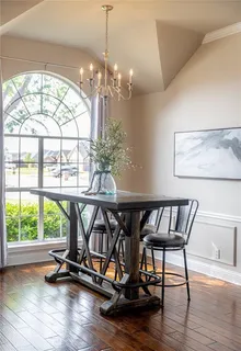 a view of a roof deck with table and chairs a barbeque with wooden floor and fence