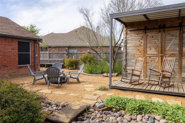 a backyard of a house with table and chairs