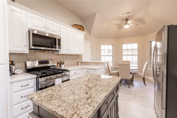a kitchen with a stove and a white cabinets
