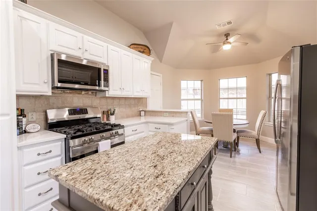 a kitchen with a stove and a white cabinets