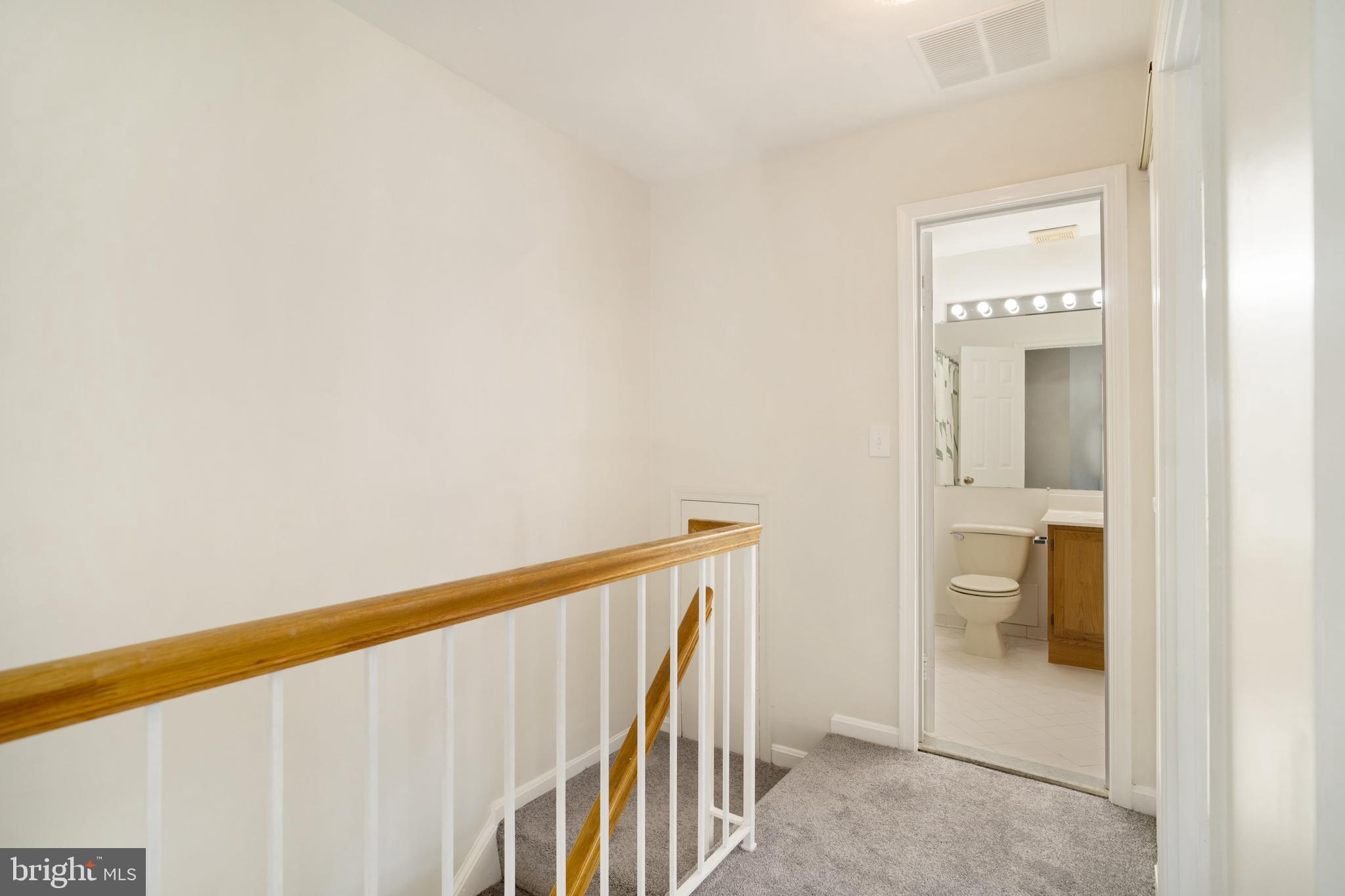 9448 Trevino Terrace, Unit 96 Laurel, MD 20708 - Photo 16 of 38 a view of a hallway with wooden floor and a bathroom