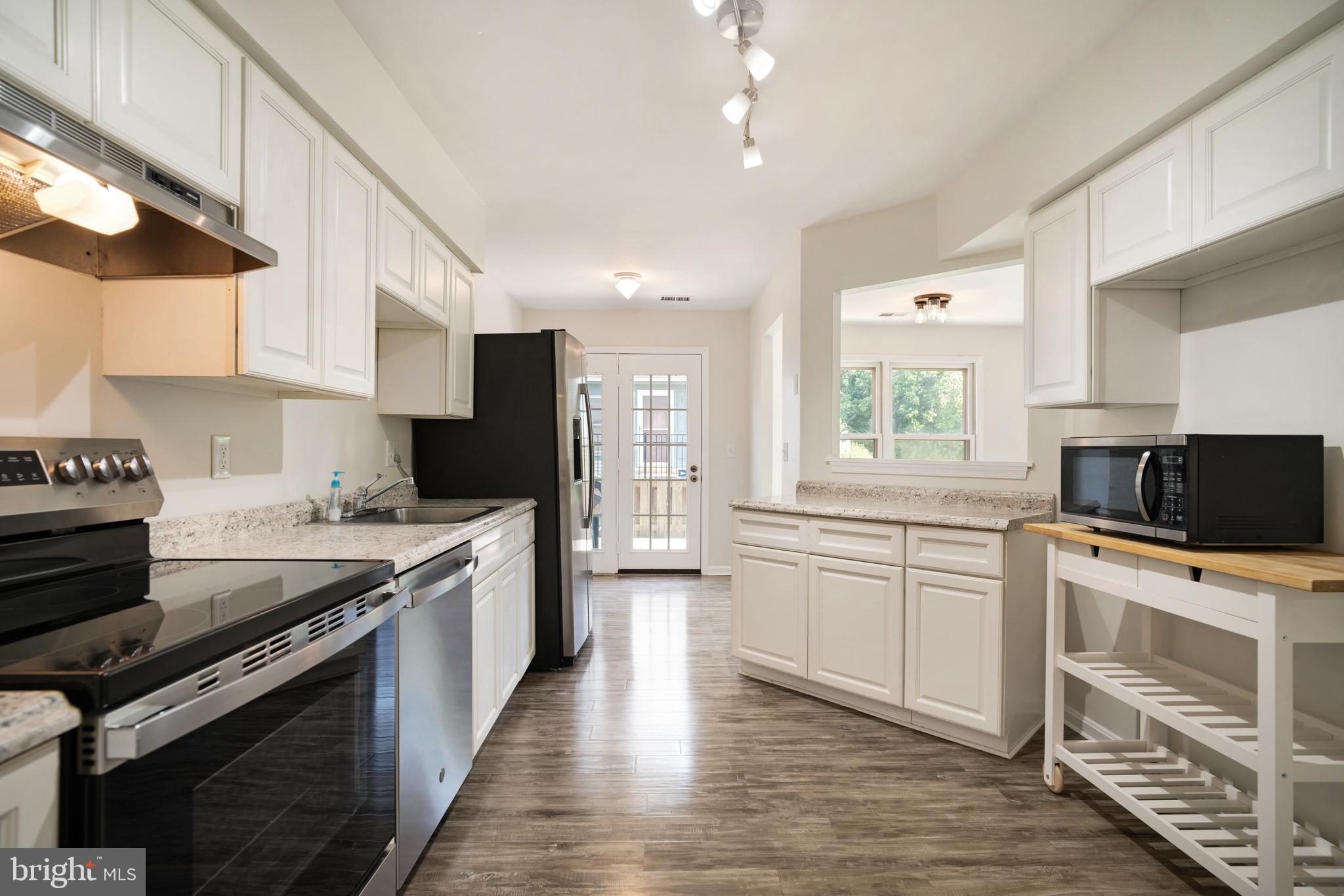 9448 Trevino Terrace, Unit 96 Laurel, MD 20708 - Photo 3 of 38 a large kitchen with stainless steel appliances granite countertop a stove top oven a sink dishwasher and a refrigerator
