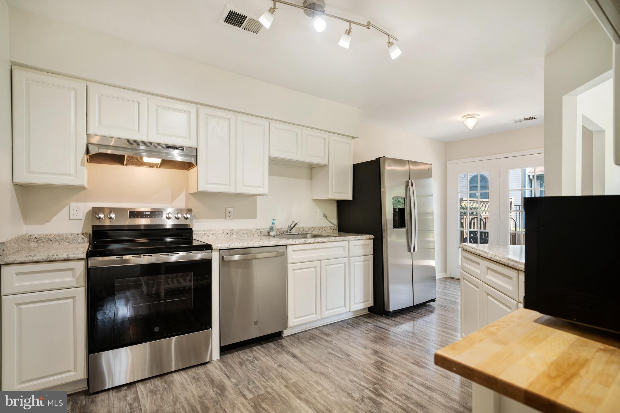 9448 Trevino Terrace, Unit 96 Laurel, MD 20708 - Photo 4 of 38 a kitchen with stainless steel appliances a stove sink and refrigerator