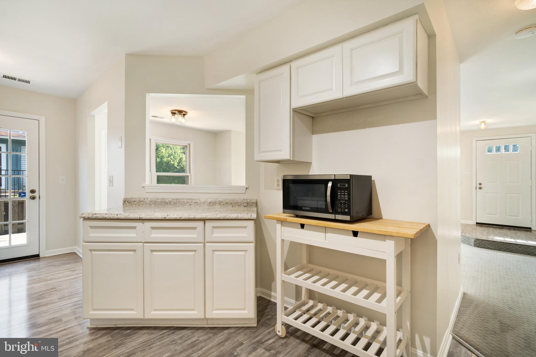 9448 Trevino Terrace, Unit 96 Laurel, MD 20708 - Photo 7 of 38 a kitchen with a stove a sink and a microwave