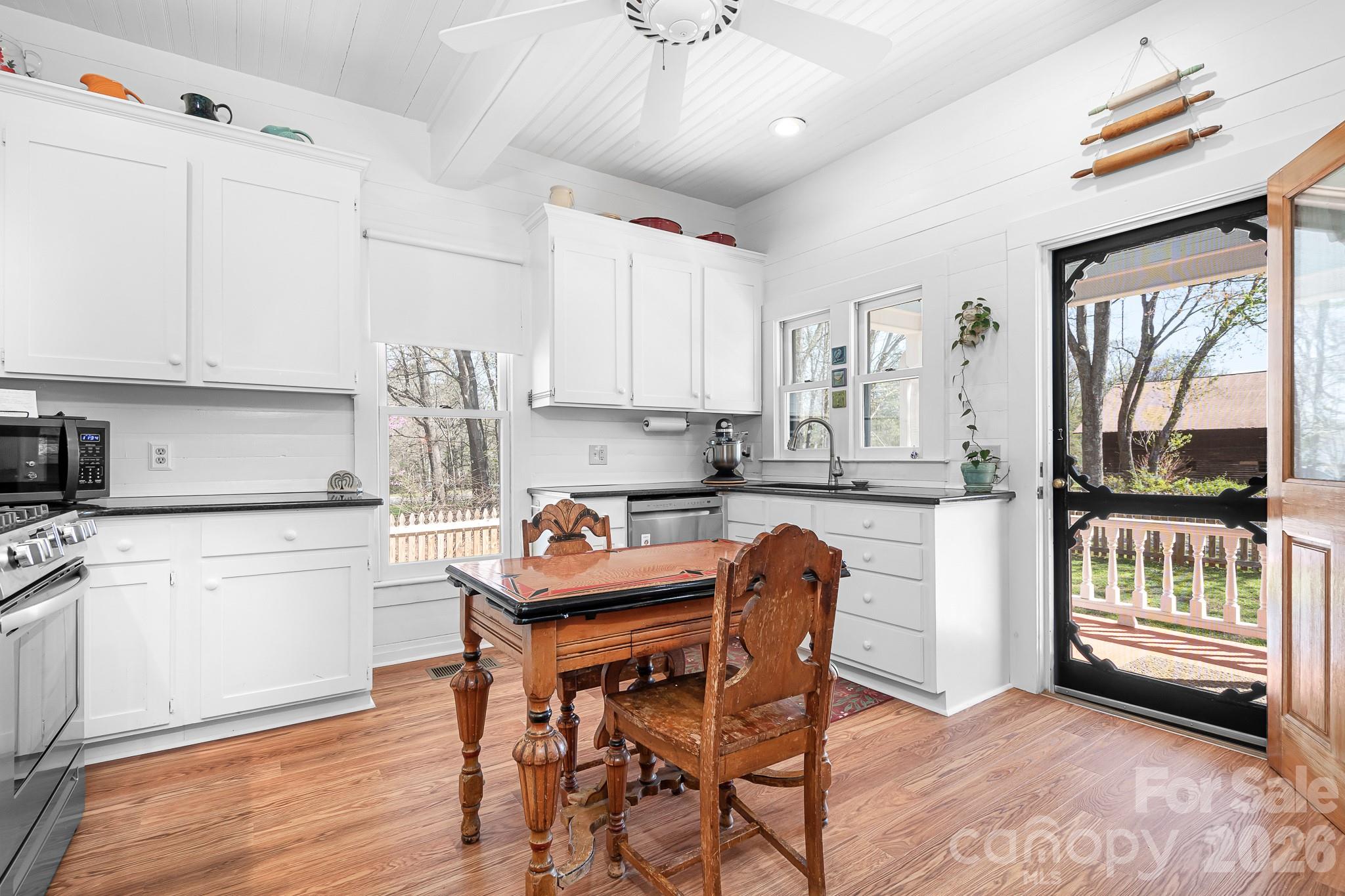 1315 Scotts Creek Road Statesville, NC 28625 - Photo 8 of 30 a kitchen with stainless steel appliances granite countertop a stove a refrigerator a sink dishwasher and white cabinets with wooden floor