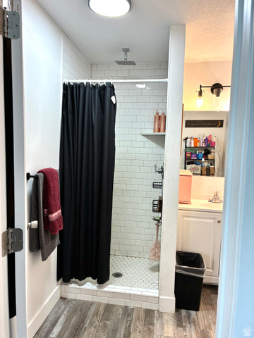 175 Eagle Street Eureka, UT 84628 - Photo 19 of 31 Bathroom with vanity, wood finished floors, a shower stall, and a textured ceiling