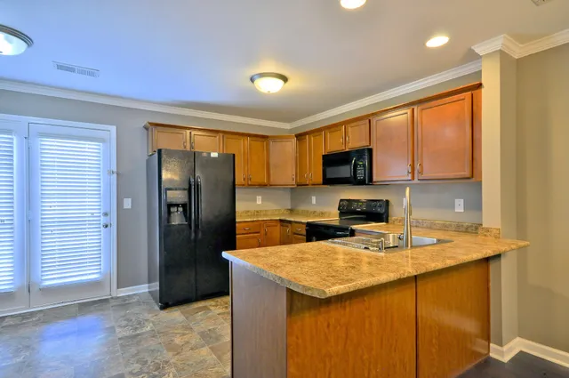 a kitchen with a sink a counter top space cabinets and stainless steel appliances