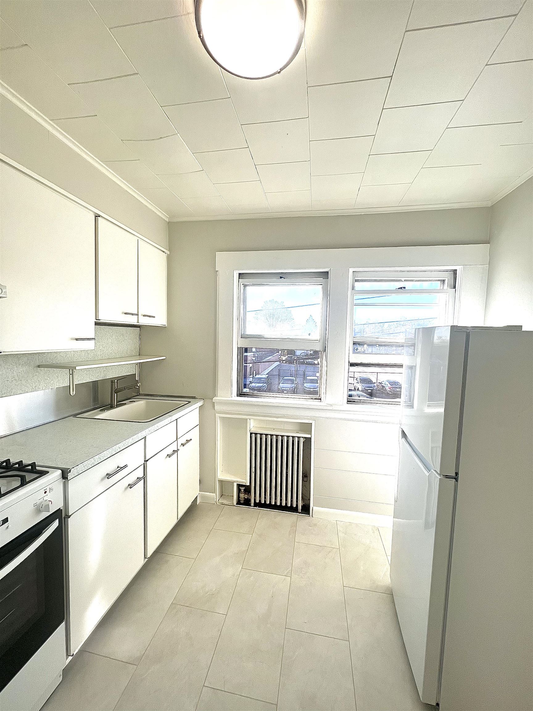 128 Hazelton Street, Unit 2 Ridgefield Park, NJ 07660 - Photo 4 of 6 a kitchen with a refrigerator and a sink