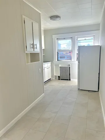 an empty room with windows and cabinet